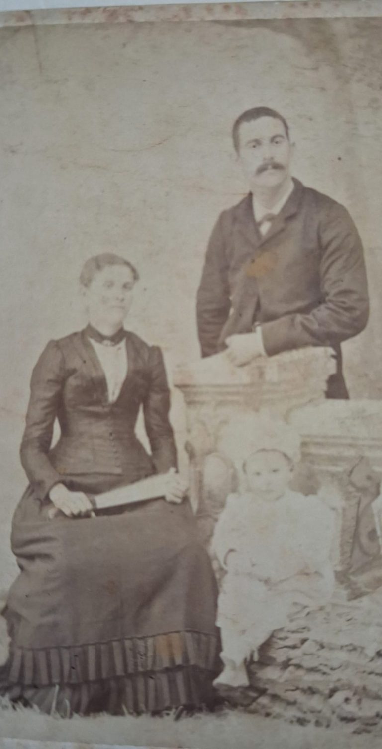 Portrait vintage d'une famille avec un couple et un enfant, tous en vêtements d'époque.